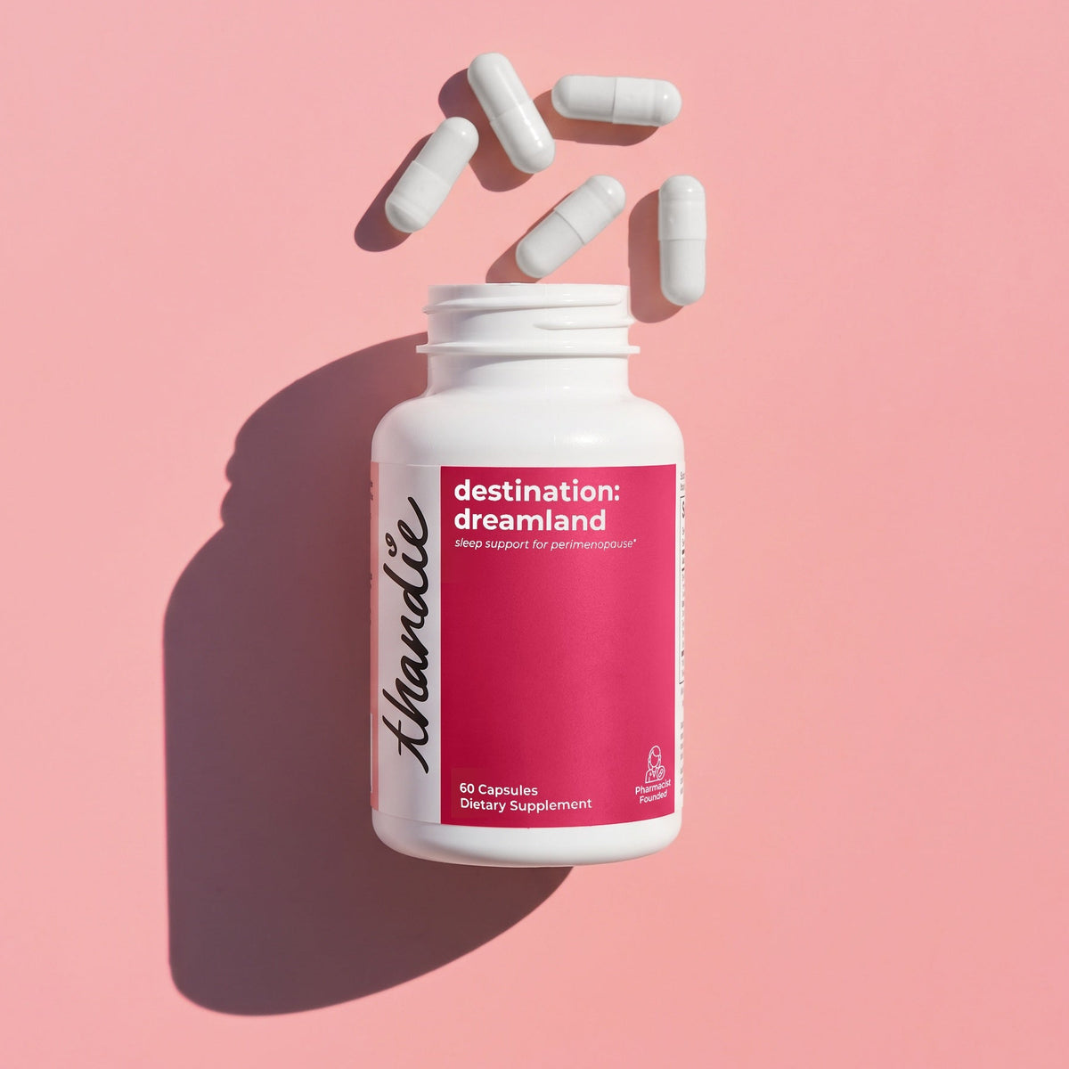 Thandie destination: dreamland sleep support supplement bottle with white capsules on a pink background